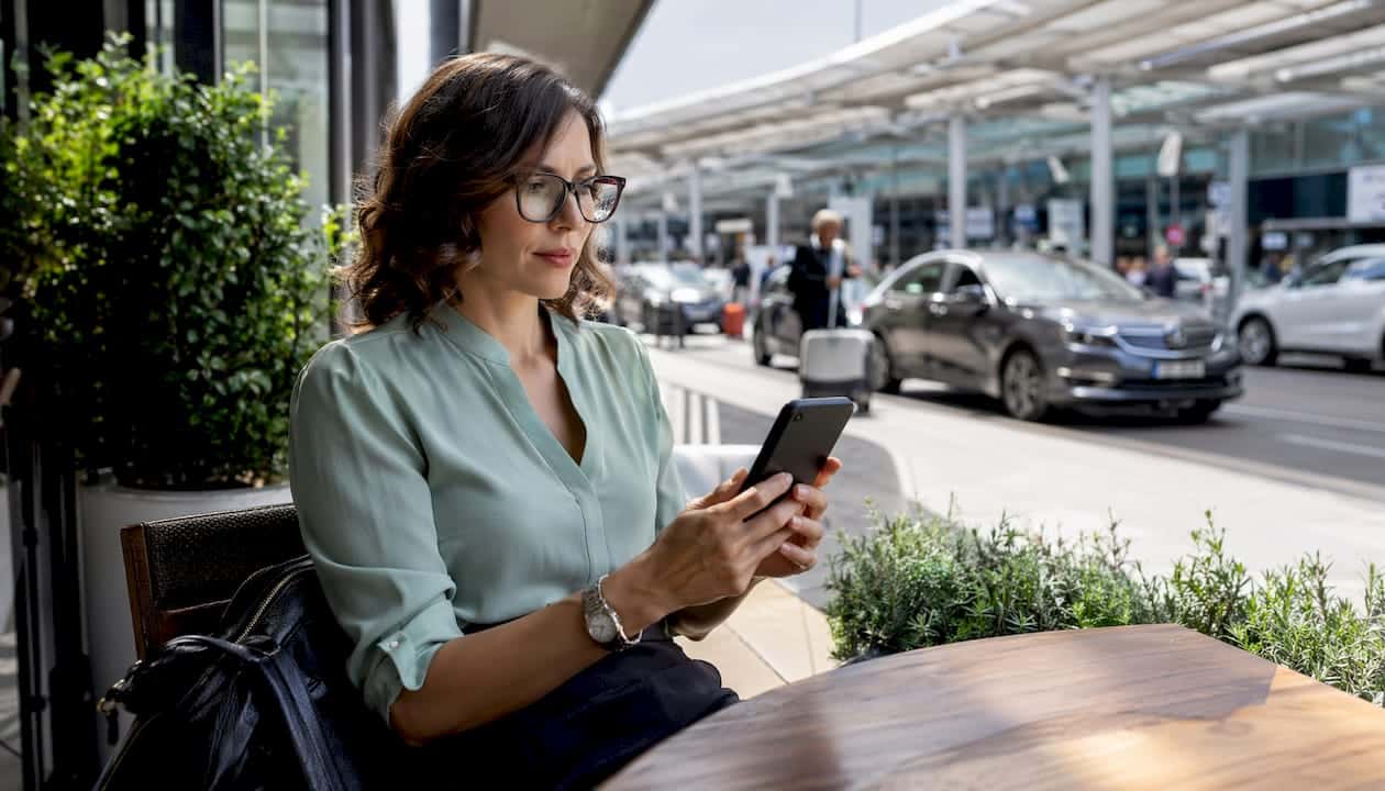 Woman confirming private transportation booking on phone