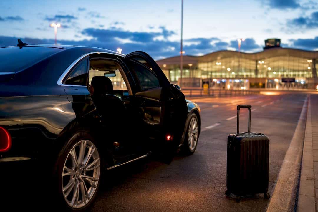 Luxury airport transfer vehicle at airport curb