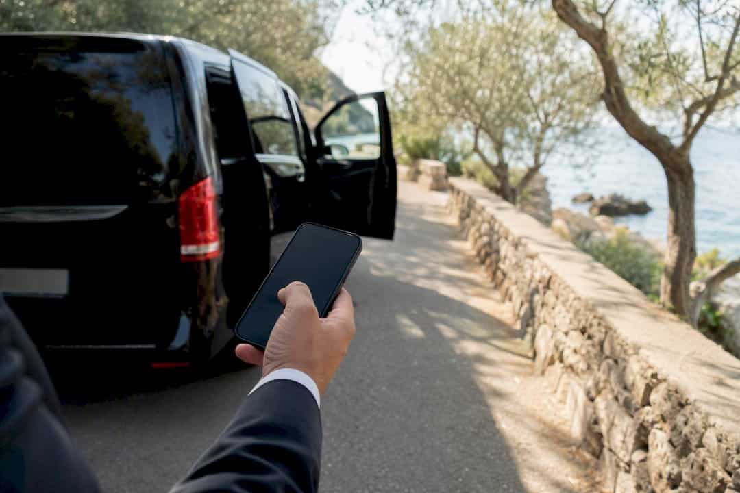 Driver holding phone by transfer vehicle door