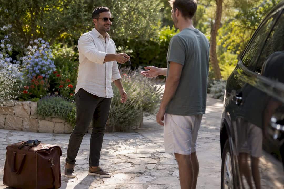 Driver handing car keys to traveler