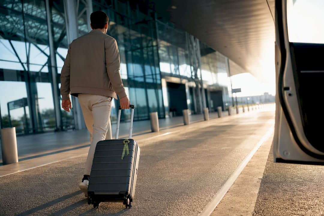 Traveler approaching airport transfer vehicle