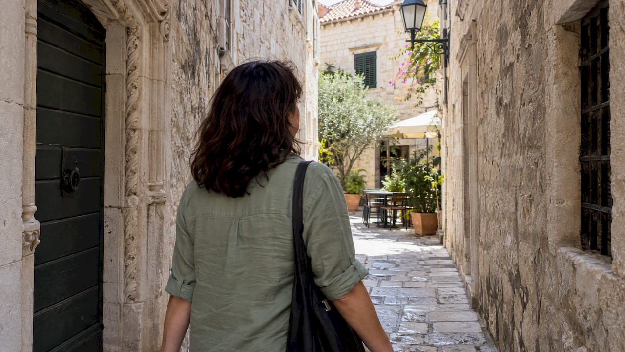 Traveler exploring a stone lane in Trogir